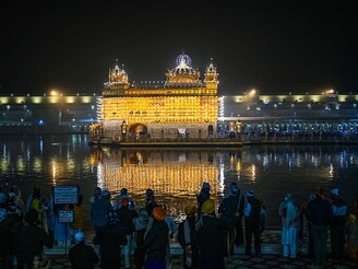 Sikh devotees pay respects at the illuminated Golden Temple in Amritsar on January 5, 2025, the eve of the birth anniversary of Guru Gobind Singh, the tenth Guru of the Sikhs.