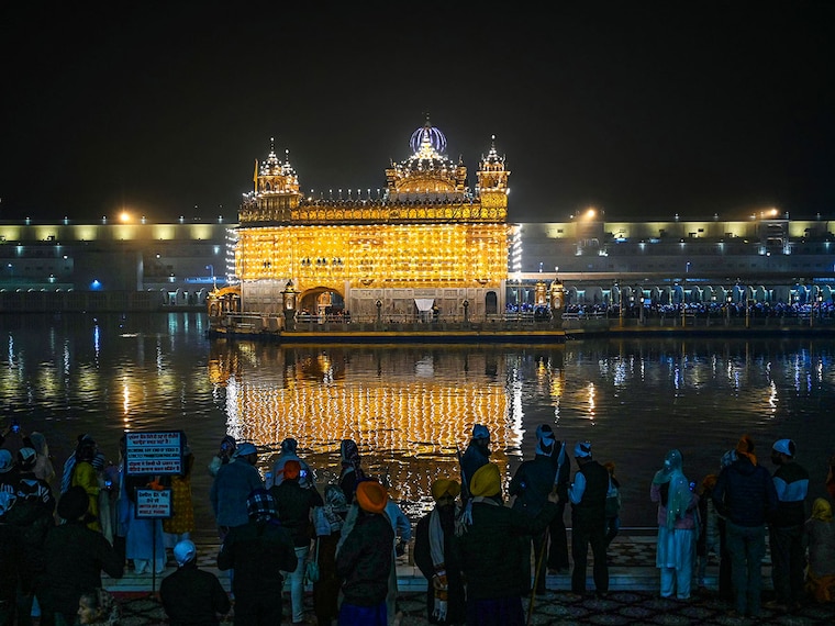 Sikh devotees pay respects at the illuminated Golden Temple in Amritsar on January 5, 2025, the eve of the birth anniversary of Guru Gobind Singh, the tenth Guru of the Sikhs.