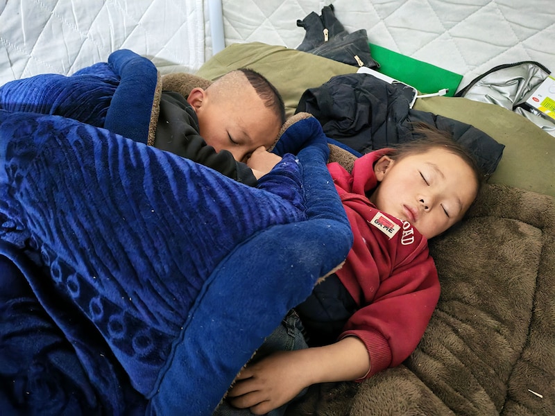 Earthquake-affected children sleep in a makeshift tent on January 8, 2025, after a 6.8-magnitude earthquake jolted Tingri county in Shigatse, Tibet Autonomous Region, China. The search for survivors continue after the strong earthquake killed at least 126 people in this remote part of western China.