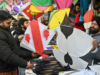 People buy kites on the eve of Lohri festival at a market in Amritsar on January 12, 2025.