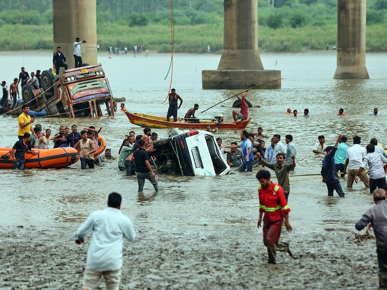 Rescuers and locals look for survivors after several vehicles fell into a river following the collapse of a portion of a bridge in Mujpur near Vadodara in the Indian state of Gujarat, Wednesday, July 9, 2025.