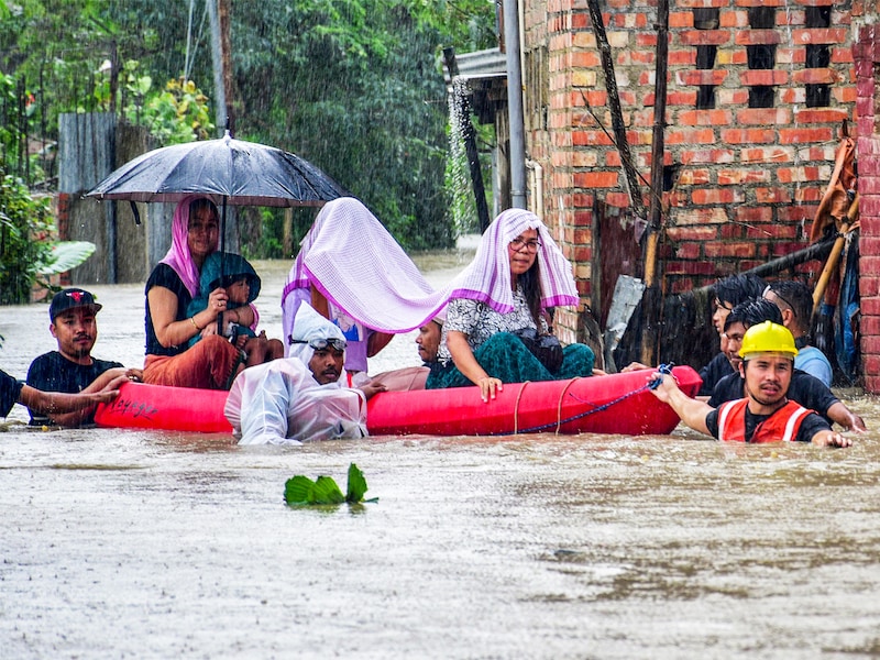 Flood-affected people are moved to safer places through a water-logged road during rains in Imphal East, Manipur, India, on June 2, 2025.