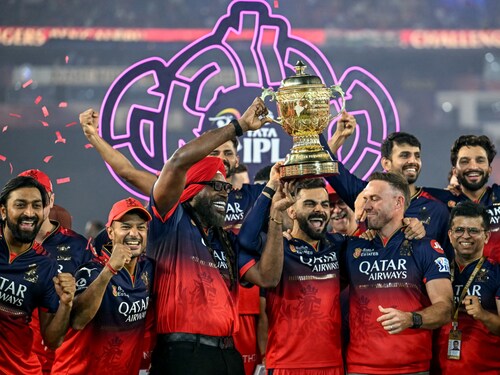 Royal Challengers Bengaluru"s Virat Kohli (C), along with his former teammates AB de Villiers (centre R) and Chris Gayle (centre L), celebrates with the trophy after winning the final match of the Indian Premier League (IPL) Twenty20 against Punjab Kings at the Narendra Modi Stadium in Ahmedabad on June 4, 2025.