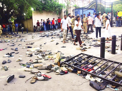 Fans stand next to abandonned shoes and a fallen barrier following a stampede during celebrations, a day after Royal Challengers Bengaluru"s victory at the Indian Premier League (IPL) Twenty20 final cricket match, outside the M. Chinnaswamy Stadium in Bengaluru on June 4, 2025. At least 11 people were killed in a stampede on June 4, as a tightly packed crowd celebrated the victory of their home cricket team in the Indian city of Bengaluru, the state"s chief minister said. Image:  AFP