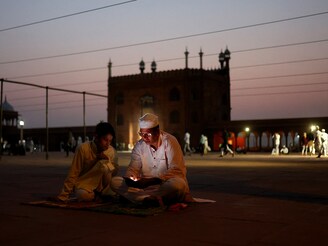 A Muslim man reads verses on his mobile phone at Jama Masjid on the occasion of Eid al-Adha, in the old quarters of Delhi, India, June 7, 2025.