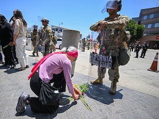 Members of the clergy and other protestors place flowers at the feet of a California National Guardsman stationed outside federal buildings near the Metropolitan Detention Center in Los Angeles on June 10, 2025, amid ongoing protests in response to federal immigration operations. US President Donald Trump on June 10 claimed Los Angeles was being invaded by a "foreign enemy" and vowed to "liberate" the city after days of protests sparked by immigration raids. Trump has deployed thousands of troops, including 700 active duty US Marines, to Los Angeles, despite California authorities saying the move is unnecessary and will inflame the situation.