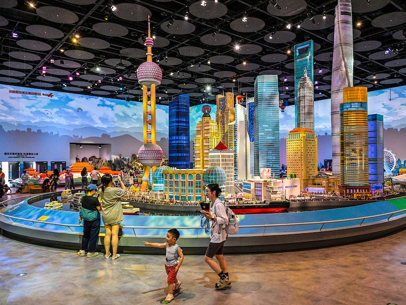 People are seen next to a Lego replica of Shanghai"s Lujiazui financial district at the new LEGOLAND Shanghai Resort, at the Jinshan district in Shanghai, on June 20, 2025. The largest LEGOLAND in the world will be officially opened in Shanghai on July 5th.