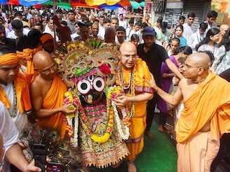 ISKCON monks carry the idol of Lord Jagannath to his rath during the annual Rathayatra celebration in Kolkata, India, on June 27, 2022. Rathayatra is an annual festival celebrating the arrival of Gods Jagannath, Subhadra, and Balaram to their aunt"s place at Gundicha temple in Puri, Odisha.