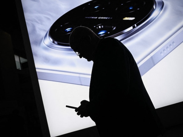 An attendee looks at his mobile phone at the MWC (Mobile World Congress), the world"s biggest mobile fair, in Barcelona on March 4, 2025.  
Image: Josep Lago/ AFP