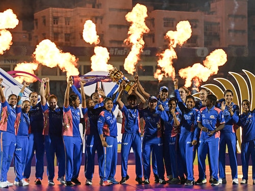 Mumbai Indians’ players celebrate with the winning trophy at the end of the Women"s Premier League (WPL) Twenty20 final cricket match between Mumbai Indians and Delhi Capitals at the Brabourne Stadium in Mumbai on March 15, 2025. MI has claimed its second WPL title with an eight run win in a thrilling final against DC that saw its straight defeat in the final.