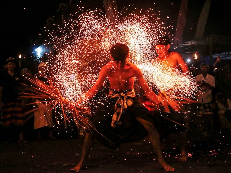 A Balinese man is hit with burnt dried coconut leaves during a firefighting ritual ahead of the holy day of Nyepi, a day of silence and self-reflection to celebrate the Balinese Hindu New Year in Paksebali village, Klungkung, Bali, Indonesia, on March 28, 2025. Image: Johannes P. Christo/ Reuters