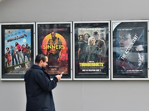 A man walks past movie posters at AMC Theater in Montebello, California on May 5, 2025. Image: Frederic J. BROWN / AFP