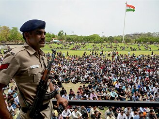 A police personnel stands guard as people assemble in a park to register as civil defence volunteers in Chandigarh on May 10, 2025, amid a surge in border tensions between India and Pakistan. Image: AFP