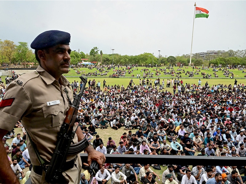 A police personnel stands guard as people assemble in a park to register as civil defence volunteers in Chandigarh on May 10, 2025, amid a surge in border tensions between India and Pakistan. Image: AFP