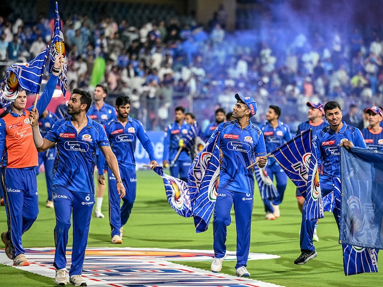 Mumbai Indians" Suryakumar Yadav (centre) and his teammates celebrate their win against Delhi Capitals at the Wankhede Stadium in Mumbai on May 21, 2025. A late blitzkrieg by Yadav, scoring an unbeaten 73 off 43 balls, helped MI secure the last playoff spot of IPL 2025, ending DC"s dreams.
