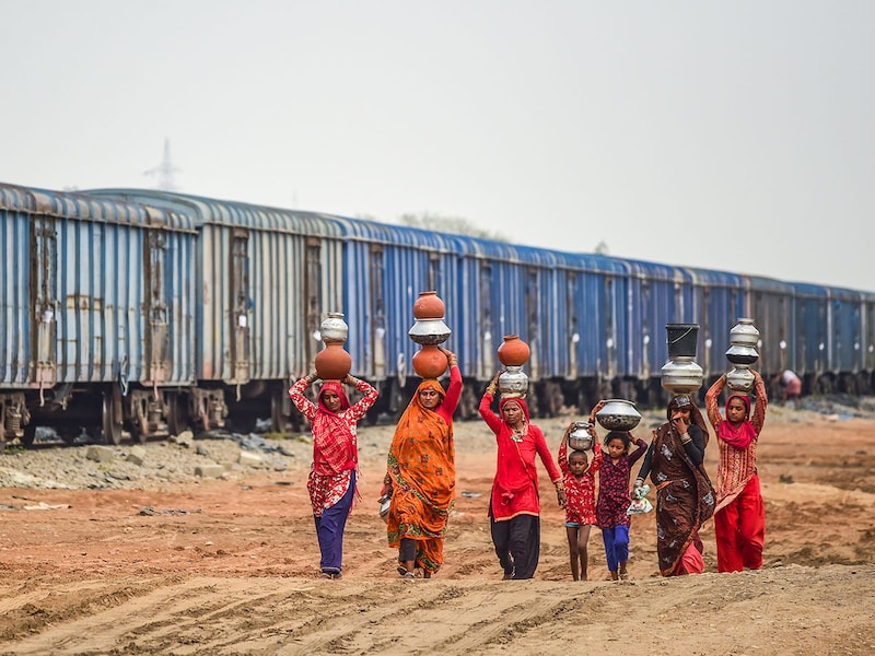 Women and children return with filled water containers from a Government Hand Pump on May 22, 2025, in Shankar Garh, the outskirts of Allahabad, India. Large parts of North India, including regions in Uttar Pradesh, Haryana, Punjab, and parts of Bihar, are currently experiencing drought-like conditions due to deficient and erratic monsoon rainfall, leading to significant agricultural and water stress. The situation is exacerbated by uneven rainfall distribution and ongoing groundwater depletion, heightening concerns over crop failures and water scarcity in these states.