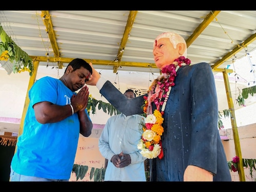  <p>In this photo taken on February 17, 2020, farmer Bussa Krishna (L), 33, offers special prayers to the statue of US President Donald Trump, at his residence in Jangaon district in Telangana state, some 120 kms from Hyderabad, ahead of the visit of US President Donald Trump to India. Die-hard Donald Trump fan Bussa Krishna celebrated the visit of his "hero" to India the only way he knows how--offering prayers to a life-sized idol of the US President in his home.</p>