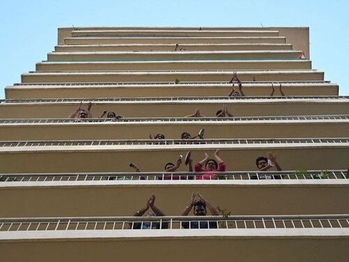  <p>GURGAON: People gather in balconies of a residential building to clap and make noise with kitchenware to thank essential service providers during a one-day Janata (civil) curfew imposed amid concerns over the spread of the COVID-19 novel coronavirus, in Gurgaon on March 22, 2020. Millions of people in India were in lockdown on March 22 as the government tests the country"s ability to fight the pandemic that has killed nearly 13,000 worldwide</p>