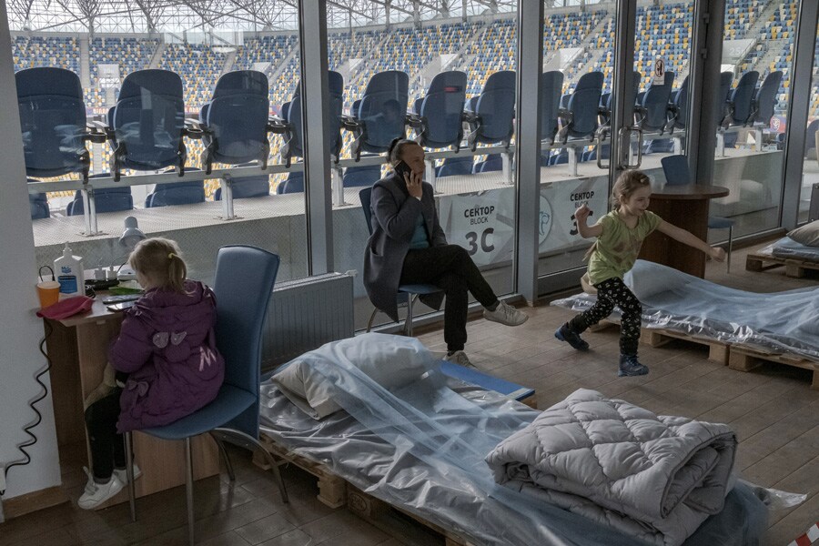 People who fled the fighting in eastern Ukraine settle into the dormitory space at a football stadium that has been converted to a reception center for internally displaced people in Lviv, Ukraine, on Tuesday, April 12, 2022. President Vladimir Putin of Russia insisted on Tuesday that his war in Ukraine would succeed and that peace talks had reached a “dead end.” (Mauricio Lima/The New York Times)