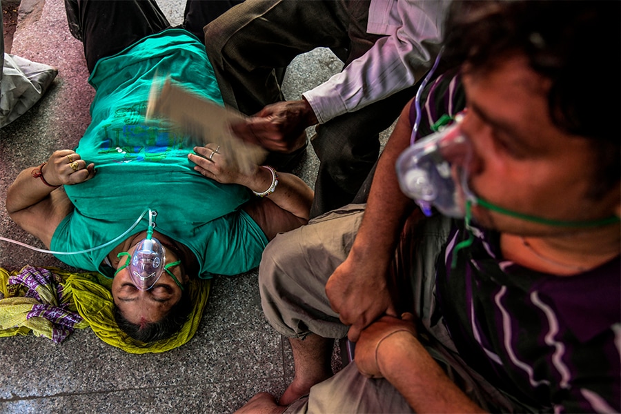 Covid patients receive oxygen provided by a Sikh house of worship on a street in New Delhi, April 25, 2021. The World Health Organization has calculated that 15 million people have died as a result of the pandemic, far more than earlier estimates, but the release of those numbers has been delayed for months because of objections from India, which disputes the calculation of how many of its citizens died. (Atul Loke/The New York Times)