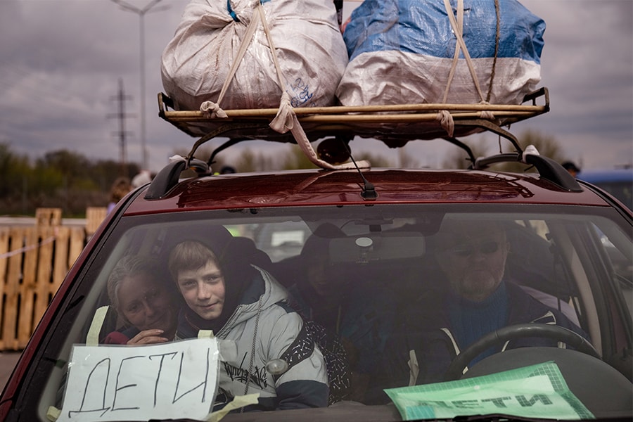  A Ukrainian family arrives in Zaporizhzhia after fleeting Russian-occupied Mariupol in Eastern Ukraine, April 21, 2022. Those arriving here from Mariupol today described cold, hunger and weeks living in basements, with days broken up only by quick dashes to the surface to cook paltry meals on open fires in the courtyard, amid neverending shelling. (Lynsey Addario/The New York Times)