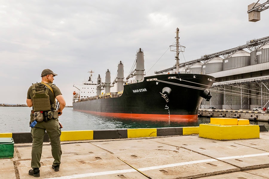 A Ukrainain soldier near grain silos during a meeting of G7 representatives, at the Odesa Port in Ukraine, July 29, 2022. The price of wheat has tumbled from its peak after Russia invaded Ukraine, but experts say one of the world’s most widely consumed foods remains in short supply and warn that a global hunger crisis still looms. (Daniel Berehulak/The New York Times)