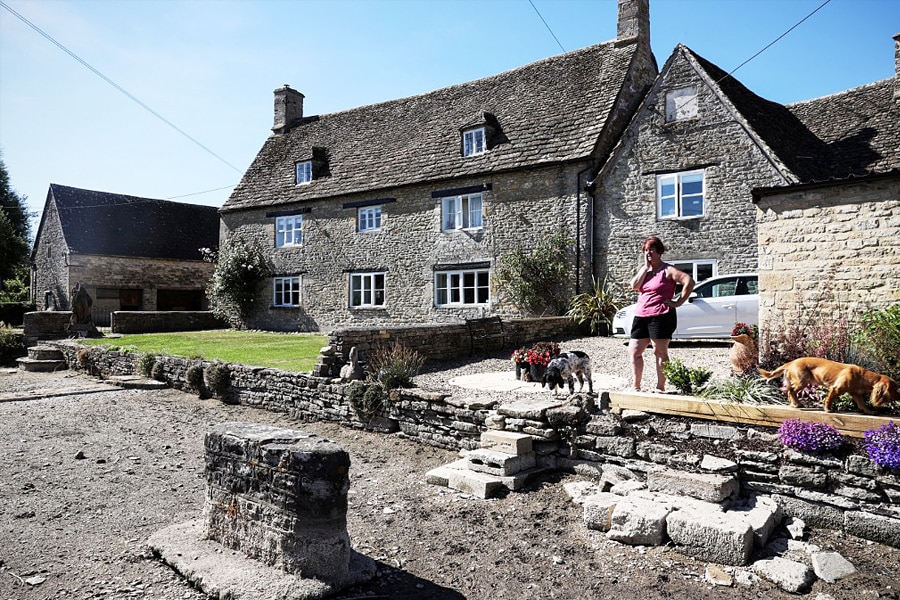 Sheila Ward stands on her driveway looking at the dried river bed of the Infant River Thames, in Ashton Keynes, England on August 8, 2022. Image: ADRIAN DENNIS / AFP