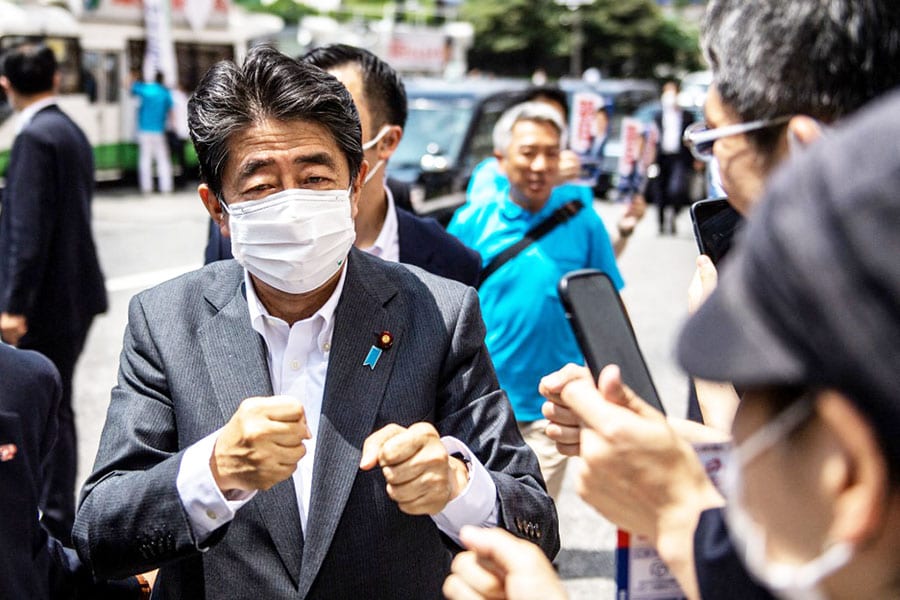 Former Japanese prime minister Shinzo Abe interacts with supporters as he joins the election campaign for Liberal Democratic Party member Kentaro Asahi (not pictured) ahead of the House of Councillors election on July 10, in Tokyo on June 22, 2022. Image: Philip Fong / AFP

