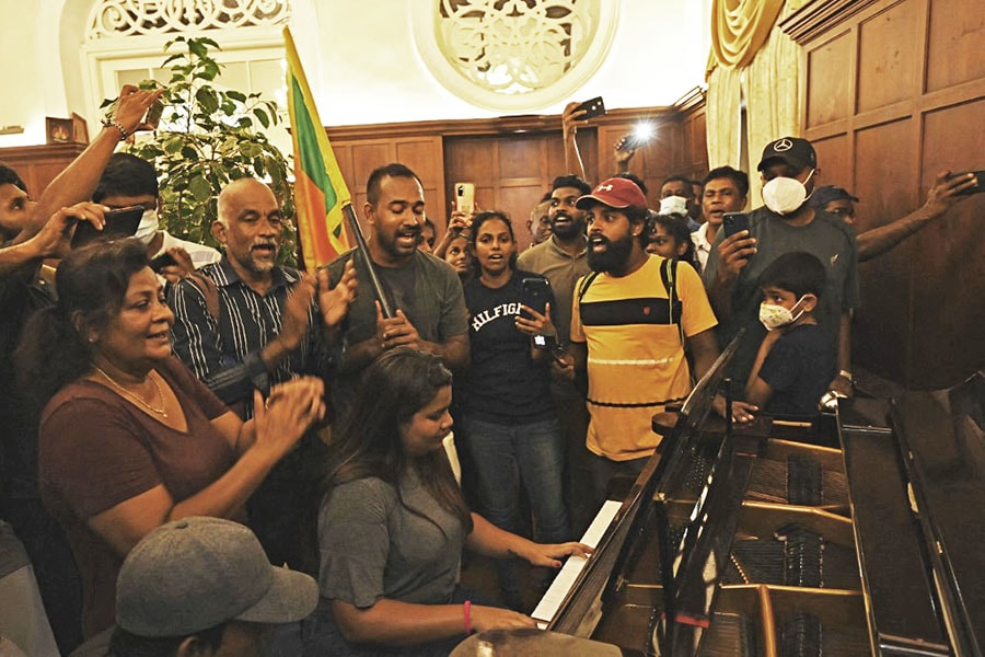 A woman plays a piano inside the Sri Lanka's presidential palace, in Colombo on July 10, 2022, a day after it was overrun by anti-government protestors. Sri Lanka's colonial-era presidential palace has embodied state authority for more than 200 years, but on July 10 it was the island's new symbol of 