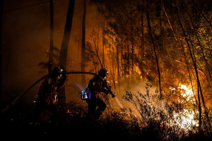 Firefighters spray water to extinguish a wildfire near Besseges, southern France, on July 7, 2022.  Image: Sylvain Thomas / AFP

