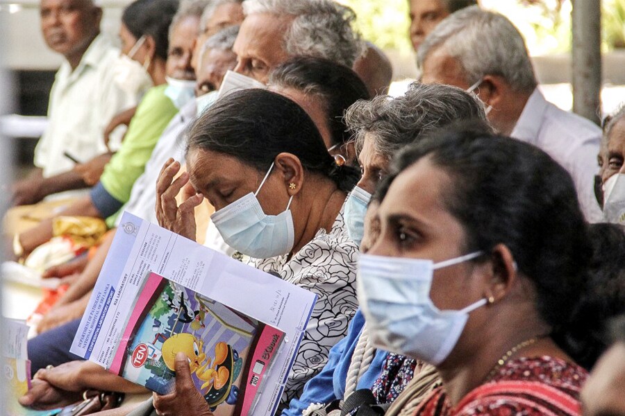 In this picture taken on July 19, 2022, patients wait for their appointment with medical staff outside the out-patient department at the National Hospital in Colombo. Entire wards are dark and nearly empty in Sri Lanka's largest hospital, its few remaining patients leaving untreated and still in pain, and doctors prevented from even arriving for their shifts. An unprecedented economic crisis has dealt a body blow to a free and universal healthcare system that just months earlier was the envy of the country's South Asian neighbours. Image: Ishara S Kodikara / AFP

