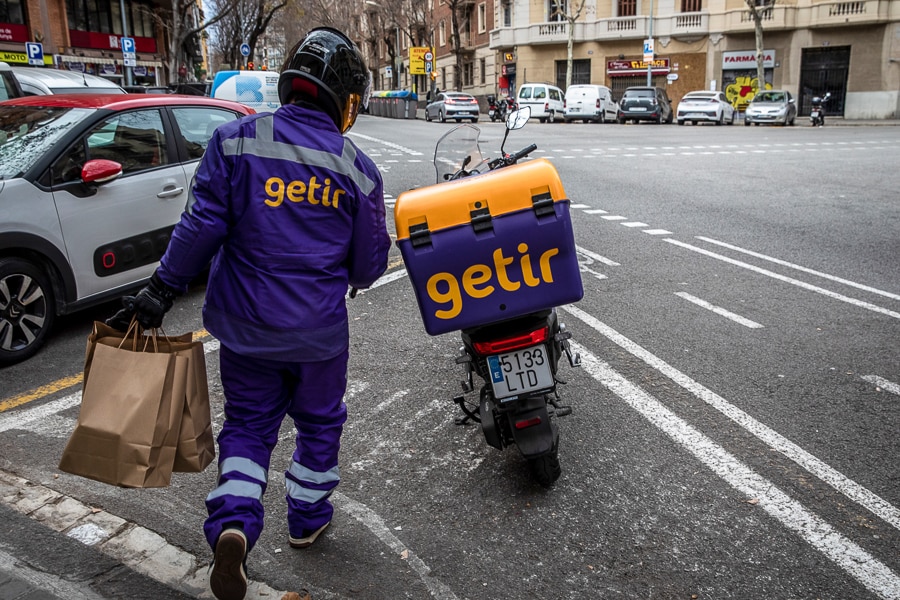 A file photo of a courier for the food delivery service Getir, as he prepares to deliver an order in Barcelona, Spain, on Saturday, Feb. 12, 2022. (Image: Angel Garcia/Bloomberg via Getty Images)