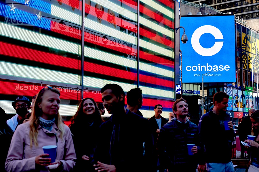 Coinbase employees gather in Times Square to see the launch of the company’s initial public offering displayed on the Nasdaq tower, April 14, 2021. Crypto companies are laying off staff, freezing withdrawals and trying to stem losses, raising questions about the health of the ecosystem. (Gabby Jones/The New York Times)