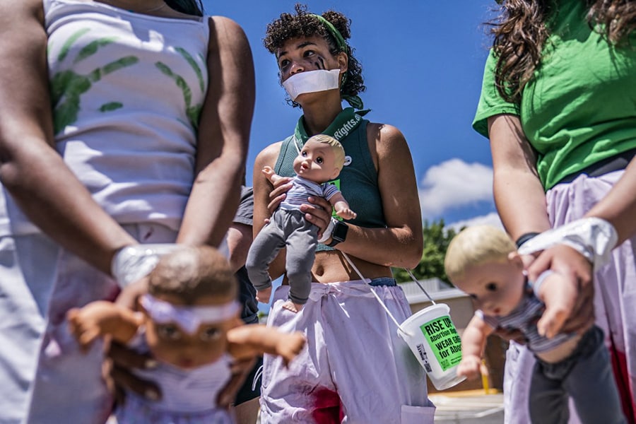 Devona Smith, 20, with Rise Up 4 Abortion Rights holds a baby doll, which the group said represented forced births, while marching to the home of Supreme Court Justice Amy Coney Barrett on June 18, 2022 in Falls Church, Virginia. According to the Rise Up 4 Abortion Rights group, the dolls represent forced births. Abortion-rights protests at the homes of conservative justices have become common since a leaked, draft decision indicated the court may overturn Roe vs. Wade. Image: Nathan Howard/Getty Images/AFP