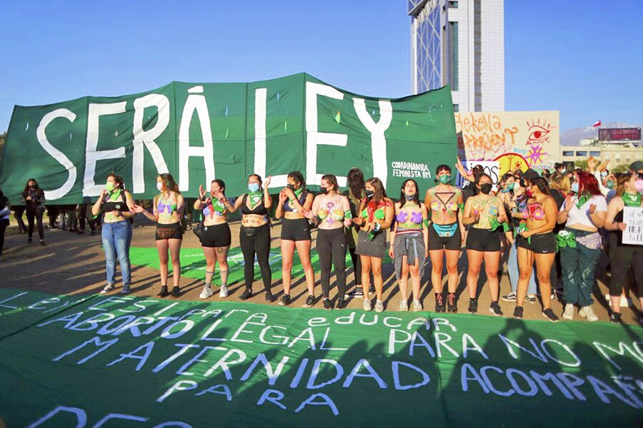 Demonstrators hold a green flag during a march celebrating after the lower house took a step toward decriminalizing abortion, on the Global Day of Action for Legal and Safe Abortion in Latin America and the Caribbean in Santiago, Chile, on September 28, 2021. In a historic initiative due to be voted on in the Senate, the lower house of Chile approved a bill to decriminalize abortion up to 14 weeks of gestation. Image: Pablo VERA / AFP