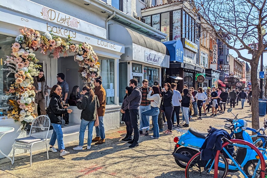 People line up outside Ukrainian-owned D Light Cafe and Bakery in Washington, DC, on March 5, 2022. - Since the Russian invasion began, lines have stretched down the street outside a Ukrainian-owned cafe in a trendy part of Washington. (Credit: Becca MILFELD / AFP)