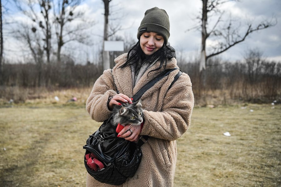 Lera, a young refugee from Ukraine holds her cat at the outside the temporary shelter and relocation center near Przemysl, south-eastern Poland on March 10, 2022. The UN says at least 2.2 million people have fled Ukraine, with more than half now in Poland. It has called the exodus Europe's fastest-growing refugee crisis since World War II. (Credit: Louisa GOULIAMAKI / AFP)