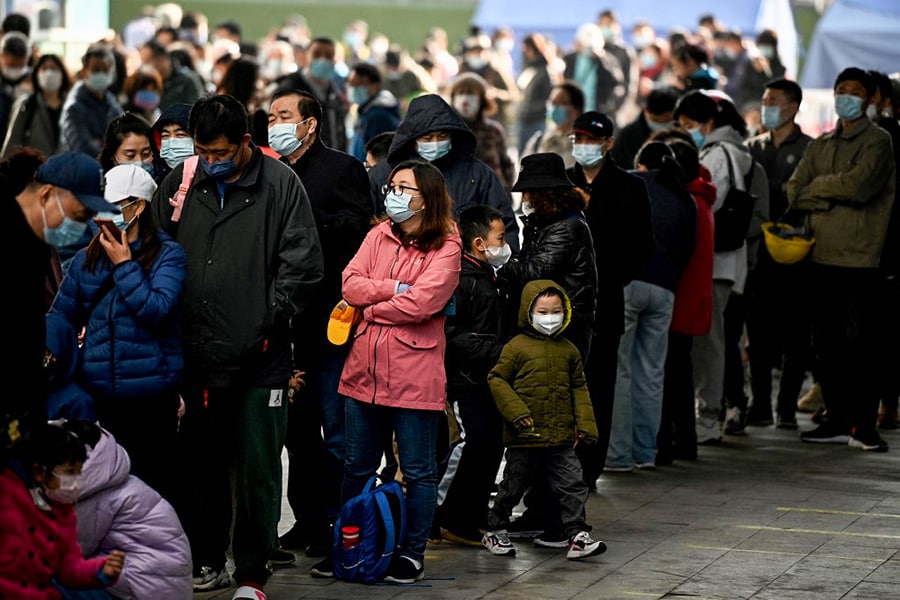 People queue to be tested for the Covid-19 coronavirus in Beijing on March 14, 2022, amid a record surge of infections across China. (Credit: Noel Celis / AFP)