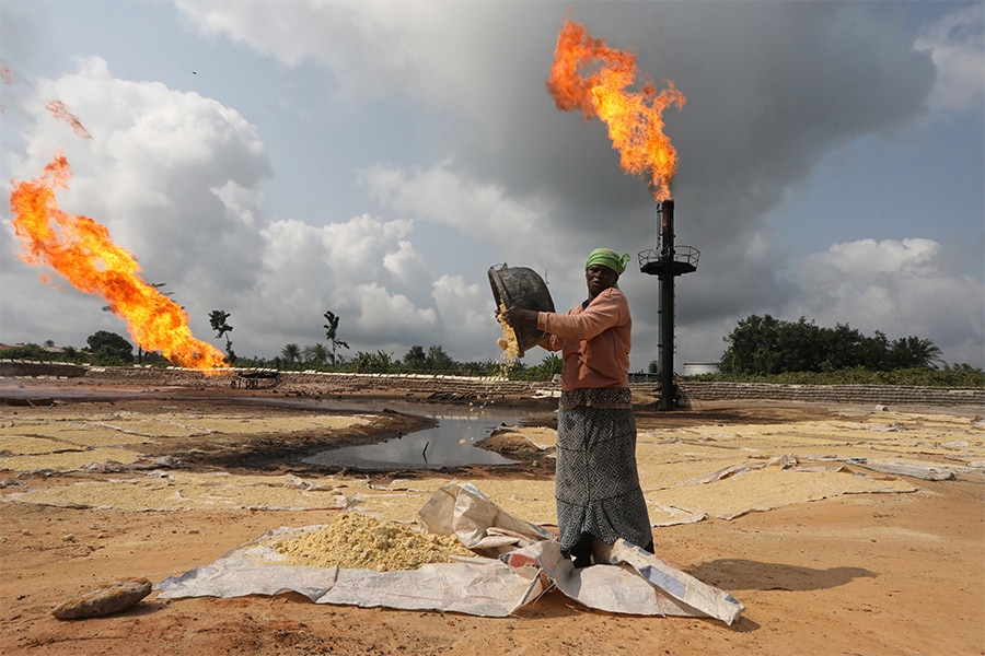 A woman near a gas flaring furnace in Ughelli, Delta State, Nigeria September 17, 2020. (Credits: Afolabi Sotunde/ Reuters)

