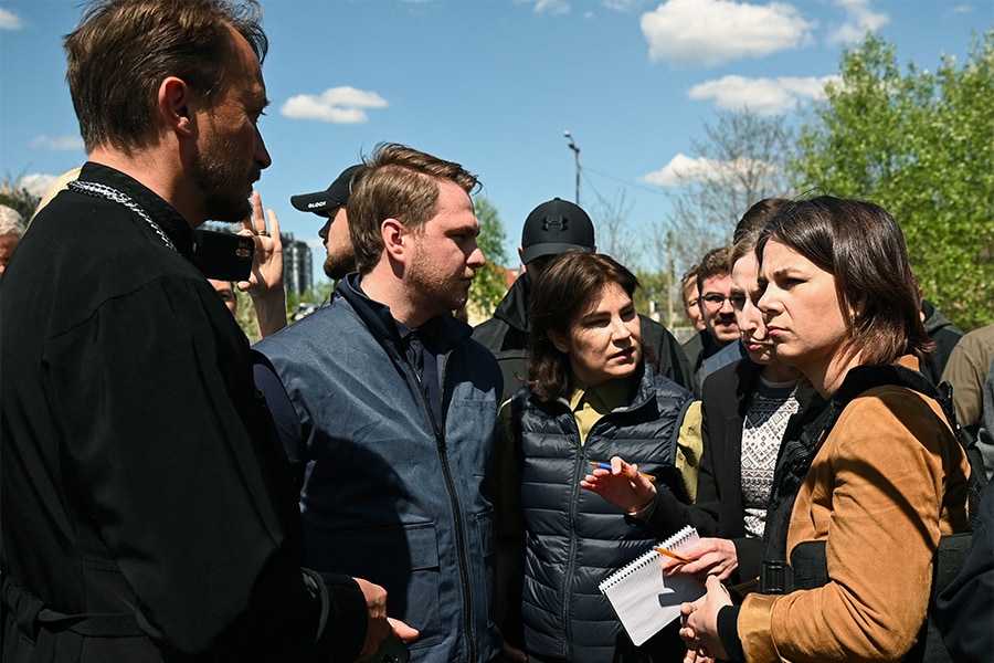 German Foreign Minister Annalena Baerbock (R) and Ukraine's Prosecutor General Iryna Venediktova (2R), German Foreign Minister Annalena Baerbock attends a surprise trip to Ukraine on May 10, 2022 visited Bucha, a suburb of Kyiv where Russian troops have been accused of killing civilians. (Credits: SERGEY VOLSKIY / AFP)