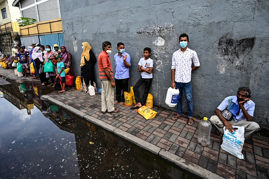 People queue up to buy kerosine for domestic use at a supply station after authorities relaxed the ongoing curfew for a few hours in Colombo on May 12, 2022. The country of 22 million people is in its worst economic crisis since independence with severe shortages of food, fuel and medicines and long power cuts. (Credits: ISHARA S. KODIKARA / AFP)