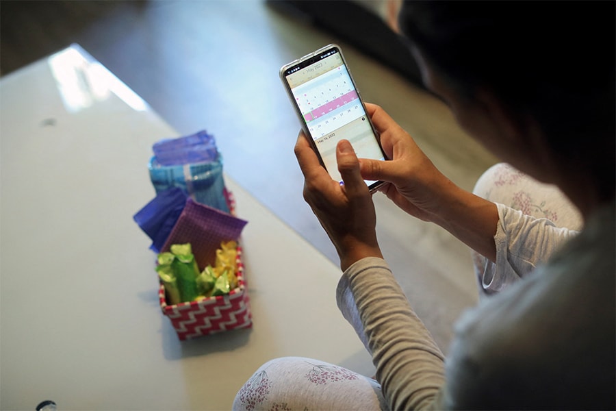 Raquel del Rio, 36, who works in police forces, poses as she observes a period calendar tracker app on her mobile phone at her home in Madrid, Spain, May 16, 2022. Spain has become the first Western country to move to give menstrual leave, with a draft bill unveiled by the government on May 17 giving women unlimited leave for period pain, provided they have a doctor's note. (Credits: Isabel Infantes/ Reuters)