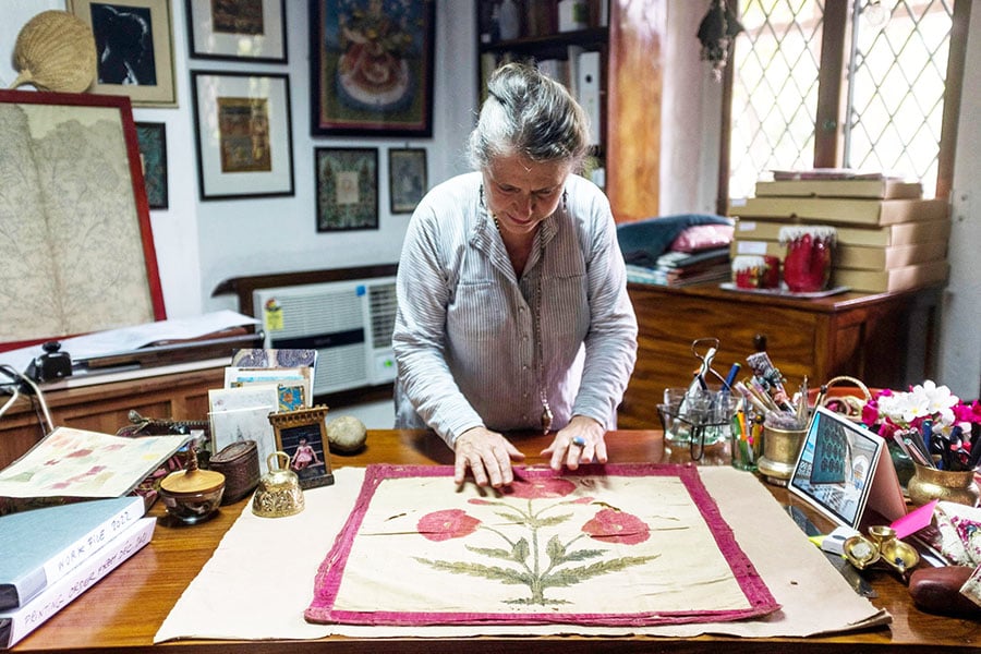 Indian naturalized textile designer Brigitte Singh displays an original fabric of the 17th century with a poppy flower design. Image:  Xavier Galiana/AFP