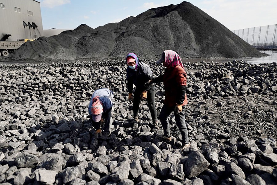 Workers sort coal near a coal mine in Datong, China's northern Shanxi province on November 3, 2021. Image: Noel Celis / AFP 