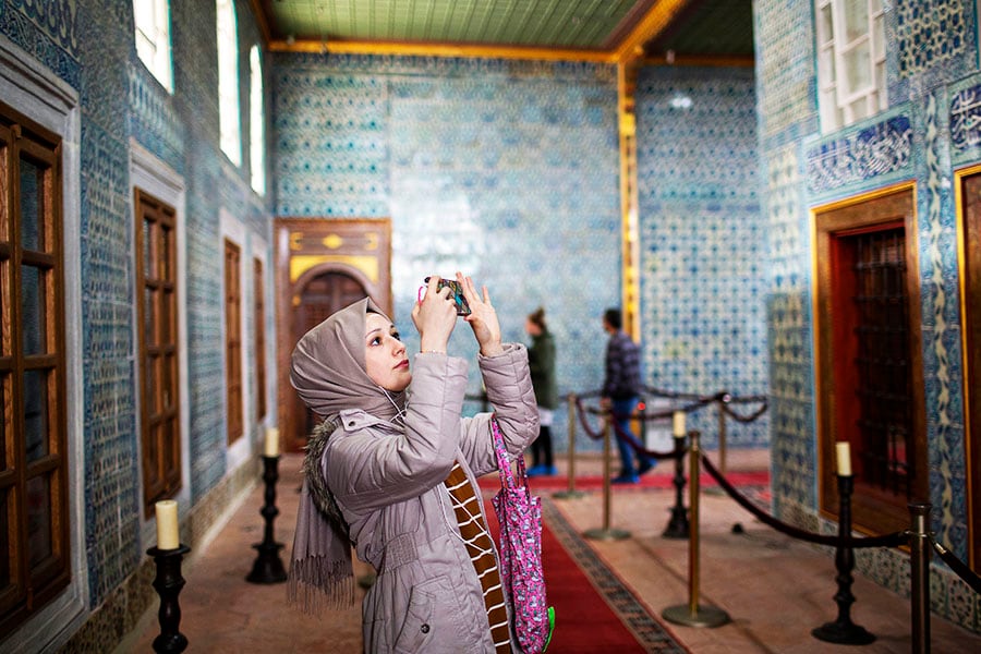 A woman takes pictures in Hünkar Kasri in Istanbul in November 2019. All the walls at Hünkar Kasri are covered in rare and exquisite Iznik tiles from the 17th century, some specially created for this building. Image: Danielle Villasana/The New York Times