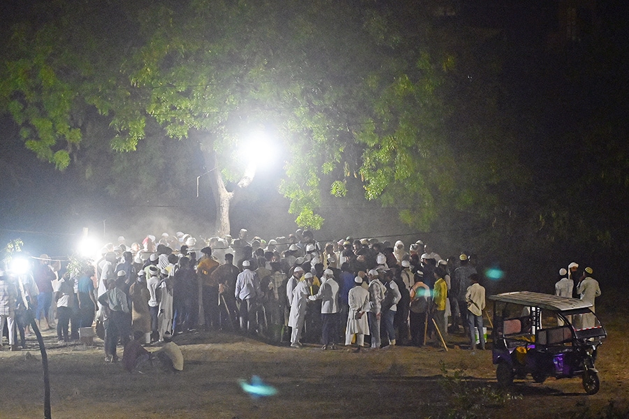 Mourners gather alongside the bodies of Atiq Ahmed and his brother Ashraf Ahmed after they were shot dead by gunmen outside Kalvin Hospital while being taken for a medical checkup in police custody in Prayagraj on April 16, 2023. Image: Sanjay KANOJIA / AFP