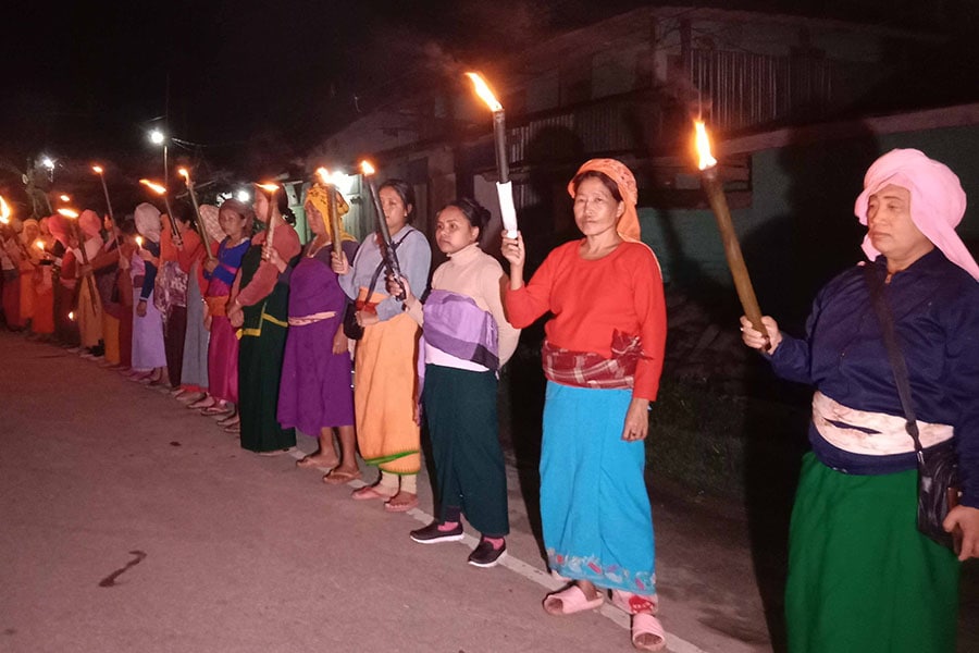 Onlookers stand near a fire started on a street in Moreh town in the northeastern Indian state of Manipur June 12, 2007; Image: Reuters