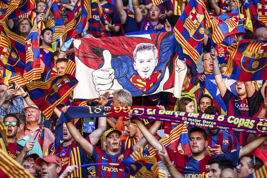 Spectators wave a huge mural of Lionel Messi as Superman during the UEFA Champions League final match between Barcelona and Juventus on June 6, 2015, in Berlin, Germany