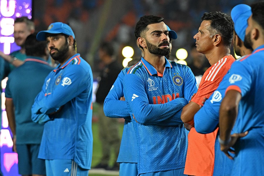 India's coach Rahul Dravid (in orange) stands along with his team players at the end of the 2023 ICC Men's Cricket World Cup one-day international final match between India and Australia at the Narendra Modi Stadium in Ahmedabad on November 19, 2023. Image: Punit Paranjpe/ AFP