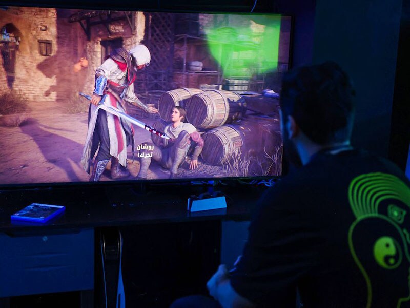 A man plays the newly released video game 'Assassin's Creed Mirage' in a cybercafe in Baghdad on October 4, 2023.
Image: Ahmad Al-Rubaye / AFP©